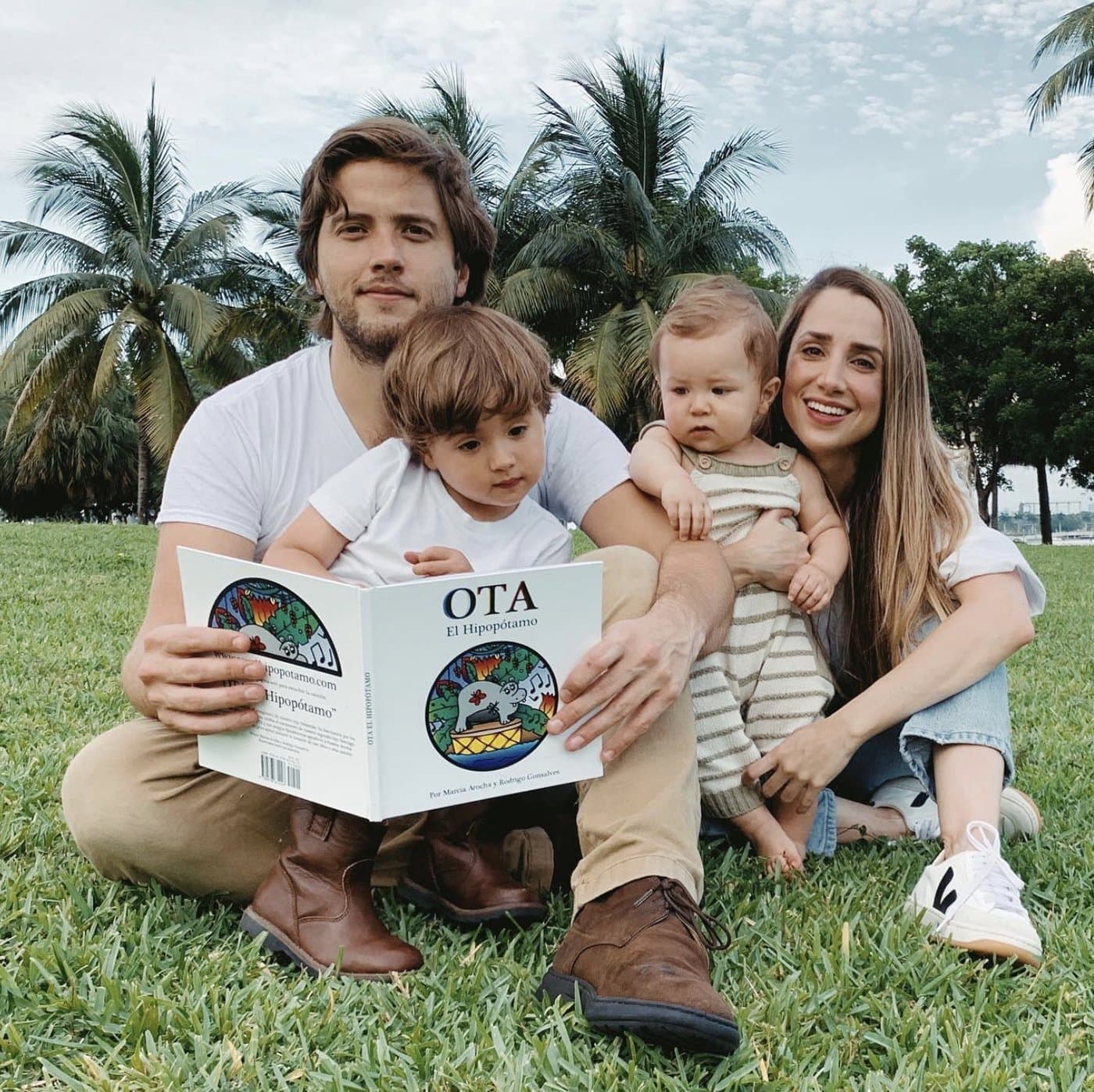 The family in a Miami park, holding the OTA El Hipopótamo book