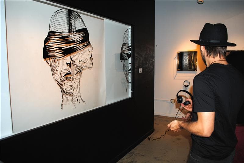 The 'No estás solo' gallery — a painting paired with headphones