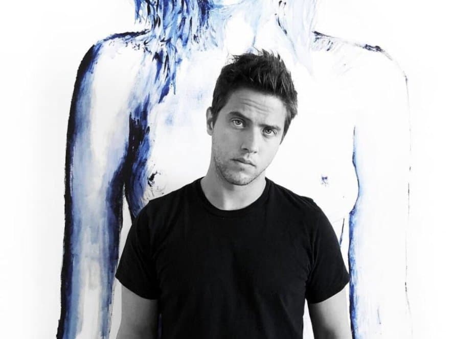 Rodrigo standing in front of a large blue figurative painting