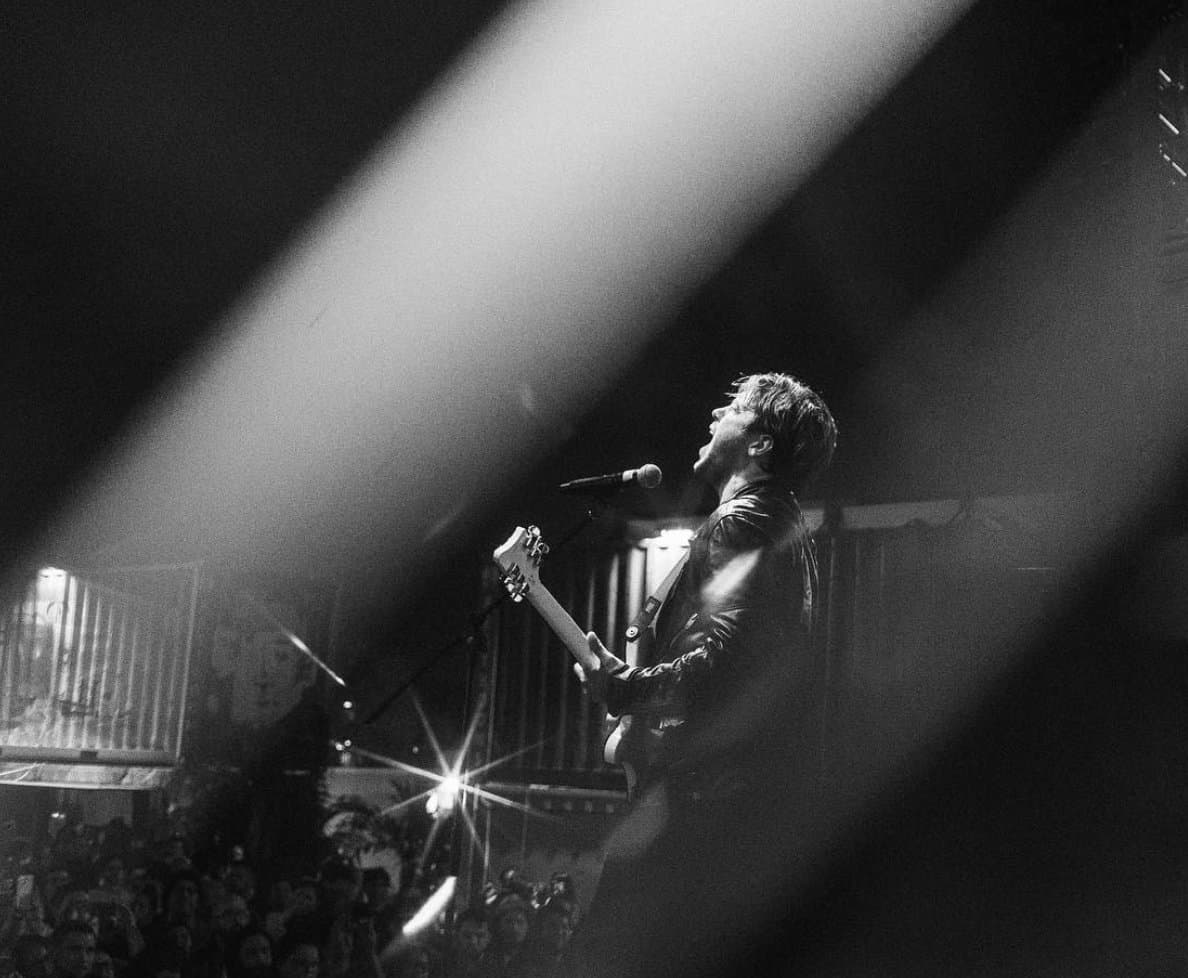 Mid-scream at the mic, shot through streaks of light